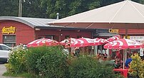 Photo de la terrasse et du bâtiment où se trouve la réception du camping.